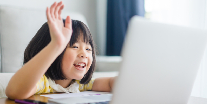 Asian girl waves hi to friend on Zoom to counter coronavirus isolation