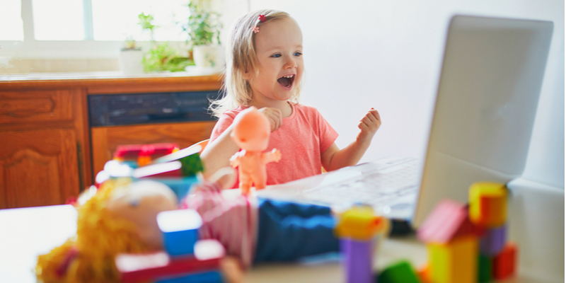 smiling little girl plays with toys on virtual playdate 