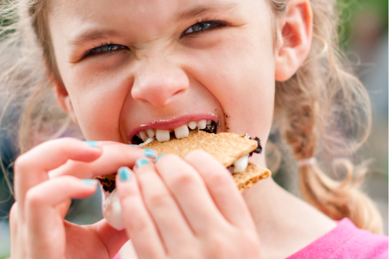 little girl eats s'more