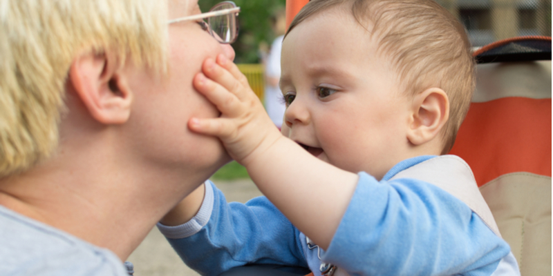 toddler plays with mother's mouth