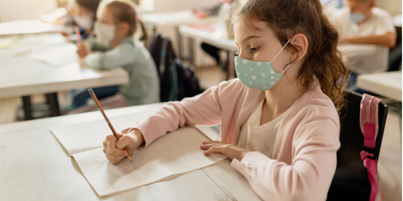 masked schoolgirl does schoolwork back to school 2020