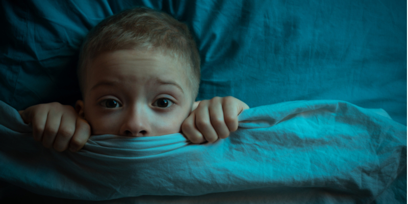 scared child holds covers up to face