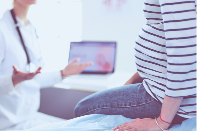 smiling woman doctor explains situation to pregnant woman