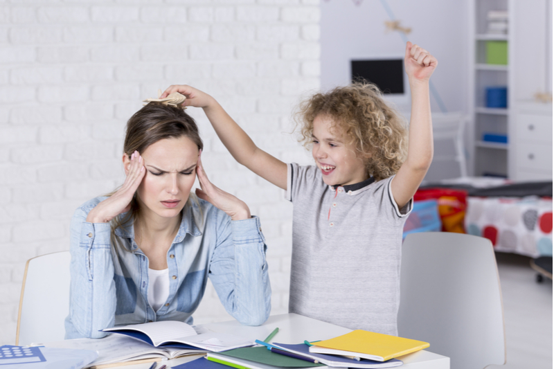 hyperactive child annoying his tired mother headache