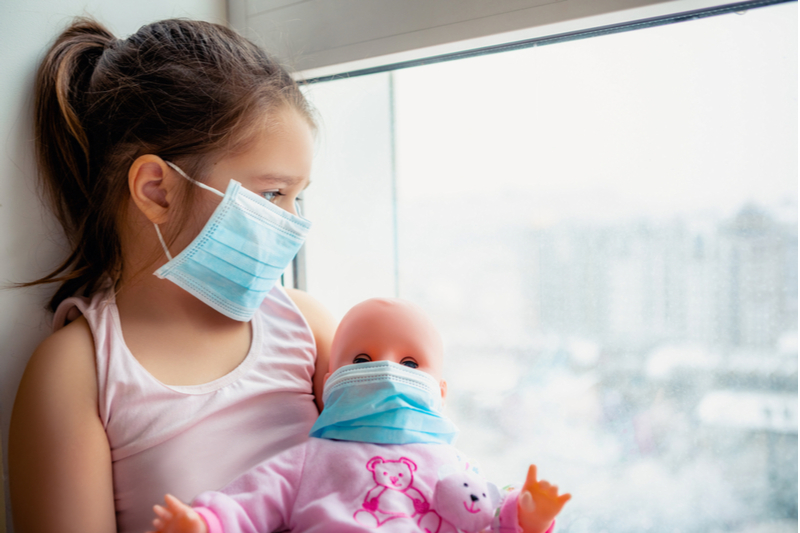 Little girl masked with masked doll in isolation with covid19