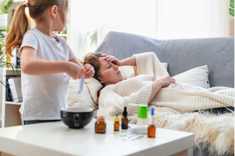 little girl wrings out cloth to place on sick moms forehead