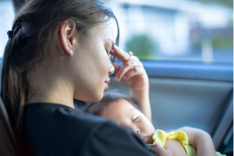 stressed out exhausted mom holds sleeping child