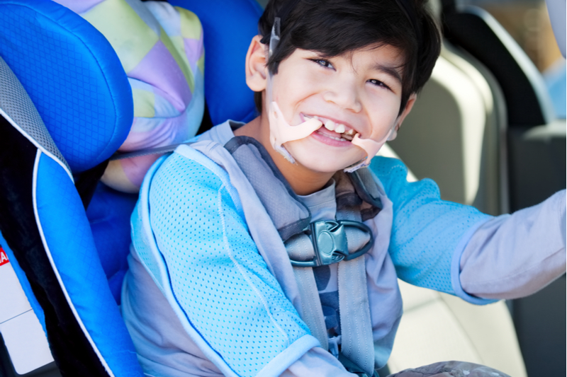 special needs child in car seat ready for a family road trip