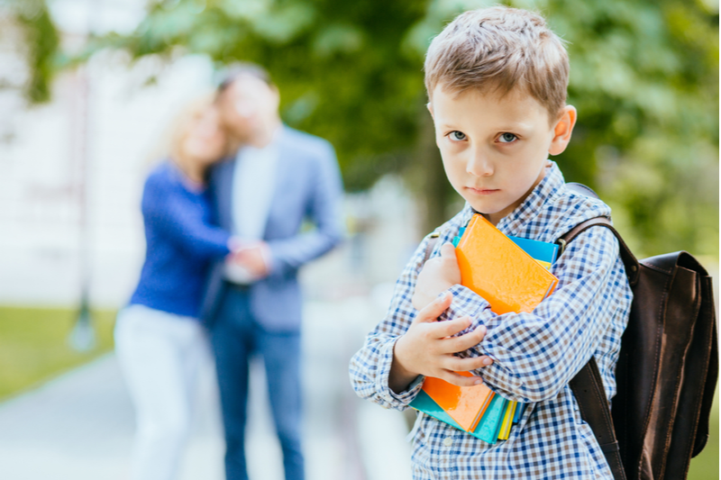 proud parents in background as young boy wrestles with back to school fears