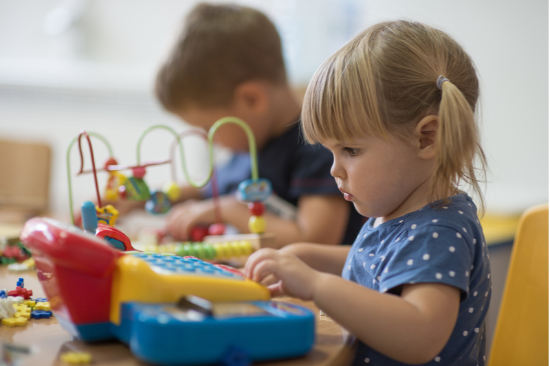 kindergartener plays with abacus