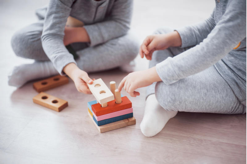 children in pajamas play with building toys