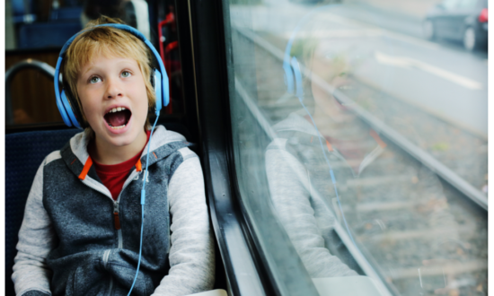 boy on the spectrum listens to earphones while traveling on bus