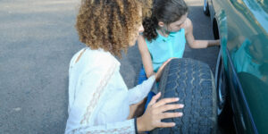 mother teaches teen daughter change tire