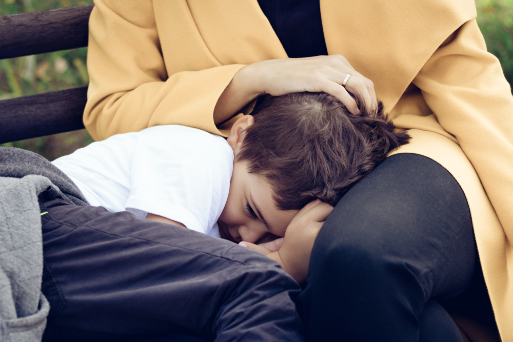 shy boy retreats to mom's lap, she comforts, strokes hair