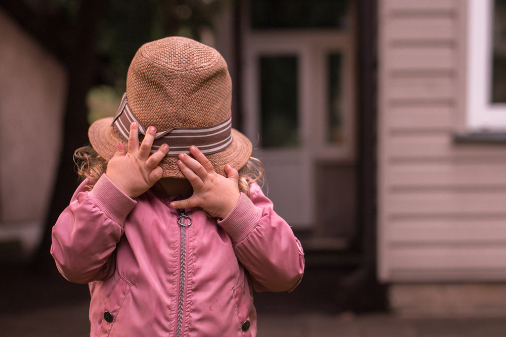 shy child hides face