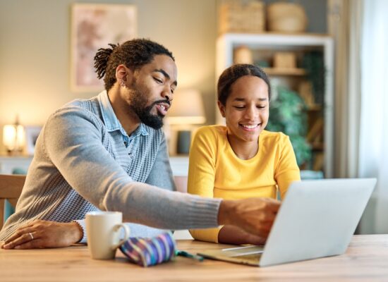 father teaches smiling daughter about elections on laptop