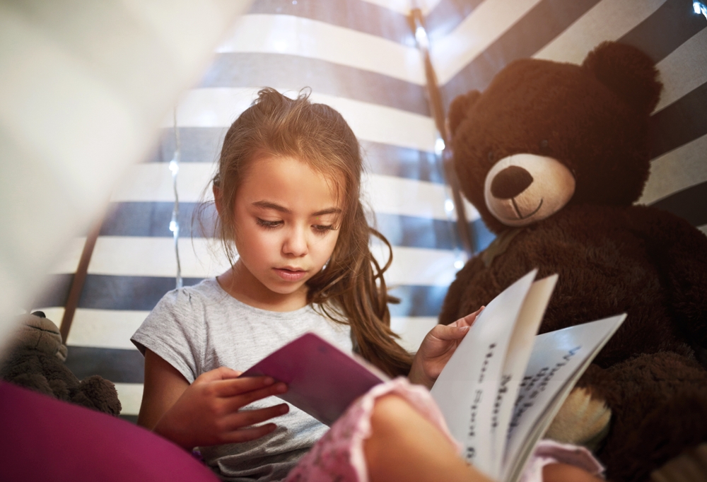 7 year old reads in bed with teddy